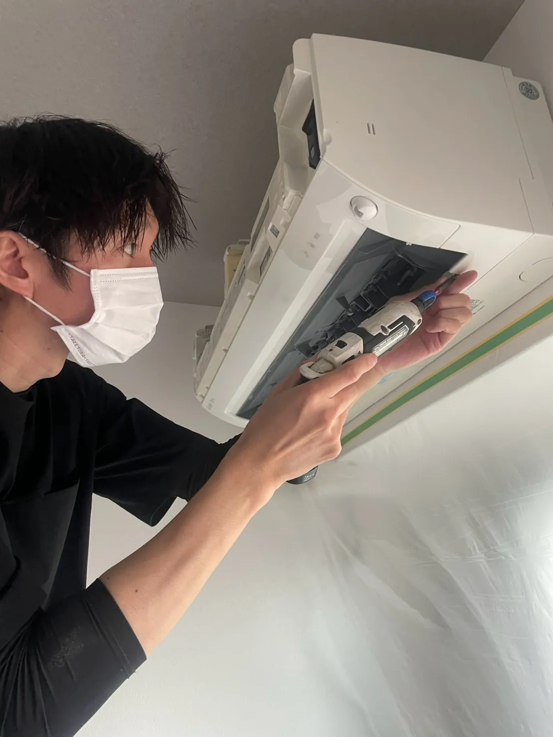 エアコンのカバーを外して分解する作業の様子