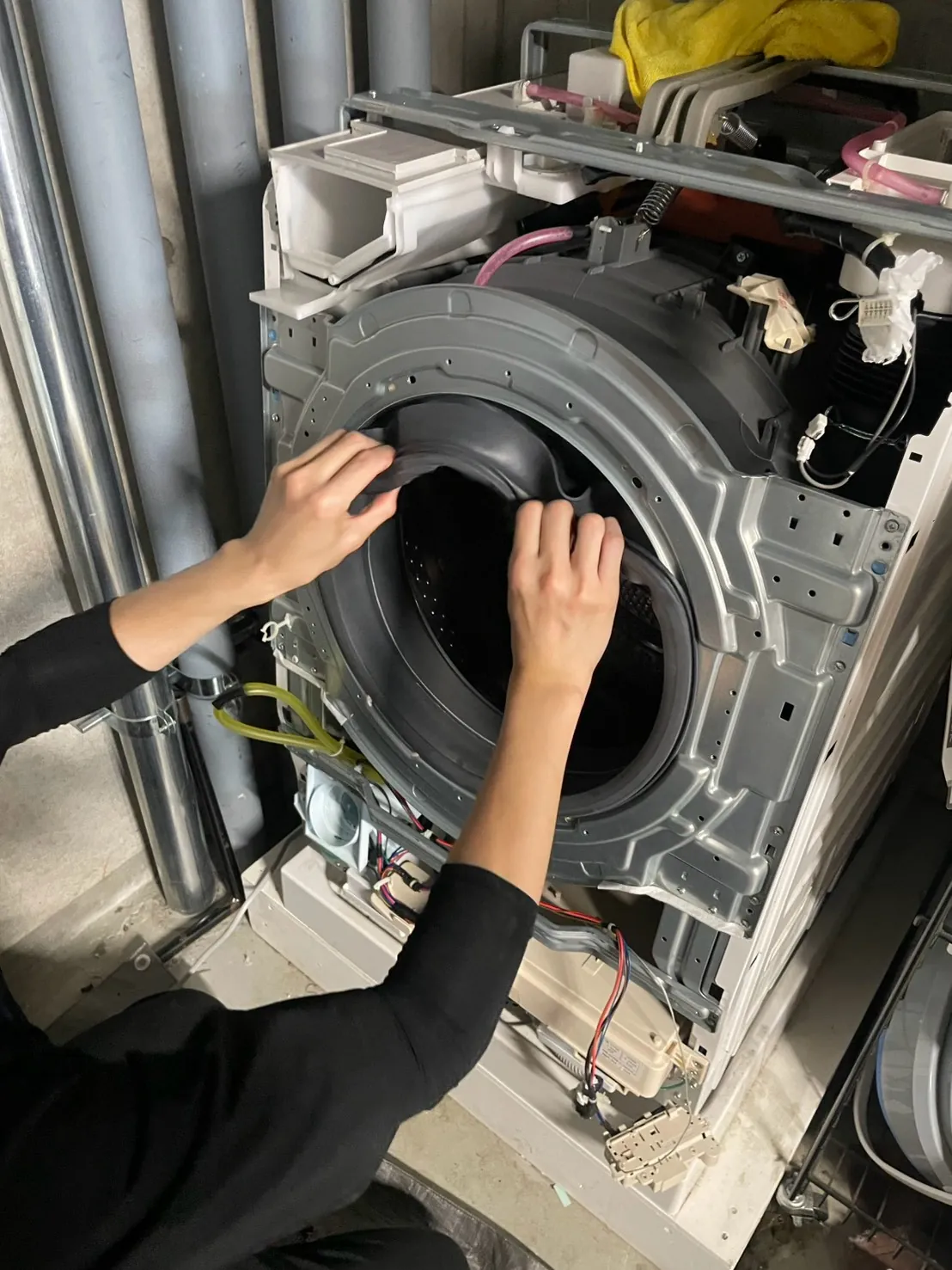 ドラム式洗濯機を分解して洗浄する作業の様子